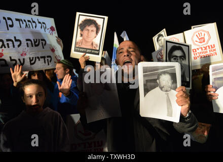 Photos de deuil israéliens tenir proches tués par des terroristes palestiniens lors d'une manifestation à l'extérieur de la prison d'Ofer, près de Jérusalem, à l'encontre de la prochaine libération de prisonniers palestiniens, le 28 octobre 2013. Israël est réglée pour libérer 26 prisonniers palestiniens qui ont mené des attaques terroristes contre les Israéliens. Les manifestants ont appelé le Premier ministre israélien Benjamin Netanyahu pour arrêter la libération de prisonniers. UPI/Debbie Hill Banque D'Images