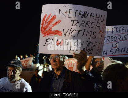 Tenir les manifestants lors d'une manifestation des signes à l'extérieur de la prison d'Ofer, près de Jérusalem, à l'encontre de la prochaine libération de prisonniers palestiniens, le 28 octobre 2013. Israël est réglée pour libérer 26 prisonniers palestiniens qui ont mené des attaques terroristes contre les Israéliens. Les familles endeuillées de victimes assassinées ont publié des photos de leurs proches et a appelé le Premier ministre israélien Benjamin Netanyahu pour arrêter la libération de prisonniers. UPI/Debbie Hill Banque D'Images