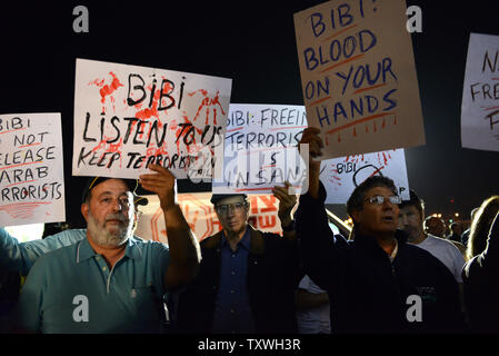 Tenir les manifestants lors d'une manifestation des signes à l'extérieur de la prison d'Ofer, près de Jérusalem, à l'encontre de la prochaine libération de prisonniers palestiniens, le 28 octobre 2013. Israël est réglée pour libérer 26 prisonniers palestiniens qui ont mené des attaques terroristes contre les Israéliens. Les familles endeuillées de victimes assassinées ont publié des photos de leurs proches et a appelé le Premier ministre israélien Benjamin Netanyahu pour arrêter la libération de prisonniers. UPI/Debbie Hill Banque D'Images