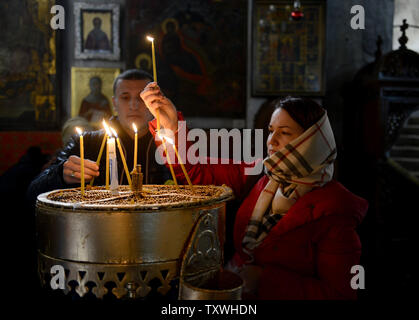 Pèlerins russes allumer des bougies dans l'église de la Nativité, traditionnellement considéré comme le site où Jésus Christ est né, dans la ville biblique de Bethléem, en Cisjordanie, le 21 décembre 2013. UPI/Debbie Hill Banque D'Images