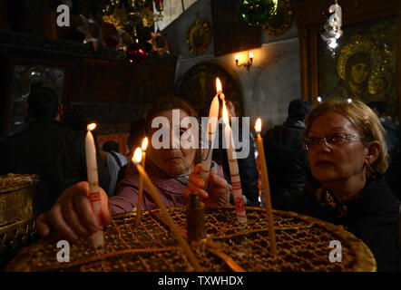 Pèlerins russes allumer des bougies dans l'église de la Nativité, traditionnellement considéré comme le site où Jésus Christ est né, dans la ville biblique de Bethléem, en Cisjordanie, le 21 décembre 2013. UPI/Debbie Hill Banque D'Images