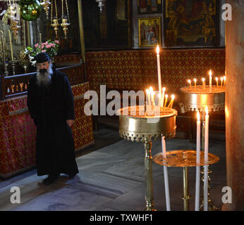 Un prêtre orthodoxe promenades près de bougies dans l'église de la Nativité, traditionnellement considéré comme le site où Jésus Christ est né, dans la ville biblique de Bethléem, en Cisjordanie, le 23 décembre 2013. Les chrétiens du monde entier sont attendus à flock à Bethléem pour célébrer Noël le 25 décembre. UPI/Debbie Hill Banque D'Images