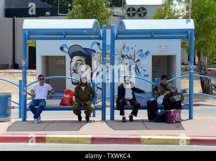 Attendre d'Israël à un arrêt de bus en face d'un abri couvert de graffitis à Sderot, dans le sud d'Israël, le 18 juillet 2014. Les forces israéliennes ont lancé une incursion terrestre dans la bande de Gaza jeudi soir dans le but de détruire les sites de lancement de roquettes et des tunnels, après 10 jours de frappes aériennes contre le Hamas. UPI/Debbie Hill Banque D'Images