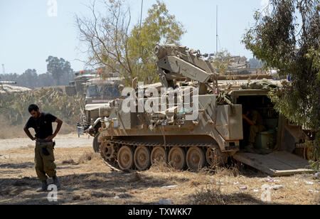 Un soldat israélien promenades à proximité d'un véhicule de transport de troupes à une zone d'étape près de l'Israël et le Hamas à la frontière de Gaza contrôlée dans le sud d'Israël, le 31 juillet 2014. UPI/Debbie Hill Banque D'Images