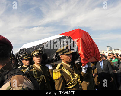 Membres des forces de sécurité palestiniennes portent le cercueil drapé du drapeau de l'Autorité palestinienne Membre du cabinet Ziad Abu Ein à son enterrement à Ramallah, en Cisjordanie, le 11 décembre 2014. Les pathologistes israéliens et palestiniens s'entendent pas sur les causes de décès après Ziad Abu Ein est mort hier peu après une confrontation avec les troupes israéliennes à une protestation en Cisjordanie. Les photos montrent une police des frontières israélienne bousculer et l'attrapant par le cou. Ziad Abu Ein's portfolio inclus l'organisation de manifestations contre les colonies israéliennes et la barrière de séparation sur l'Ouest. UPI/Debbie Hill Banque D'Images