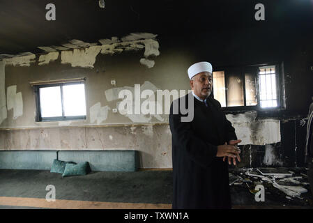 Un Palestinien inspecte les dégâts à l'intérieur d'une mosquée qui a été incendié et aspergés de graffitis dans un 'tag' prix attaque la haine par des colons juifs extrémistes à Al Jaba'ah, près de Bethléem, en Cisjordanie, le 25 février 2015. Les résidents palestiniens disent qu'ils ont vu des colons israéliens près de la mosquée lorsqu'il a été attaqué tôt mercredi matin. Une étoile de David et 'Vengeance' et 'Nous voulons que la rédemption de Sion" ont été peints à l'extérieur de la mosquée. Photo par Debbie Hill/UPI Banque D'Images
