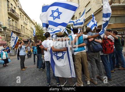 Vague de jeunes colons israéliens et le drapeau national et chanter une chanson en hébreu qui dit : Celui qui croit en Dieu n'a pas peur" au cours d'une marche de protestation dans le centre de Jérusalem, Israël, le 18 octobre 2015. Les colons ont fait une marche de protestation contre une vague de terreur poignardant les attaques en palestiniens sur les Israéliens. Photo par Debbie Hill/ UPI Banque D'Images