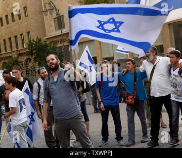 Un colon israélien vagues le drapeau national et chante une chanson en hébreu qui dit : Celui qui croit en Dieu n'a pas peur" au cours d'une marche de protestation dans le centre de Jérusalem, Israël, le 18 octobre 2015. Les colons ont fait une marche de protestation contre une vague de terreur poignardant les attaques en palestiniens sur les Israéliens. Photo par Debbie Hill/ UPI Banque D'Images