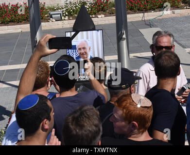 Les Israéliens de prendre des photos d'un portrait de président israélien Shimon Peres comme il se trouve dans la région de la plaza de la Knesset, à Jérusalem, Israël, le 29 septembre 2016. L'ancien combattant leader israélien décédé le 28 septembre à l'âge de 93 ans, après avoir subi un AVC majeur. Photo par Debbie Hill/UPI Banque D'Images