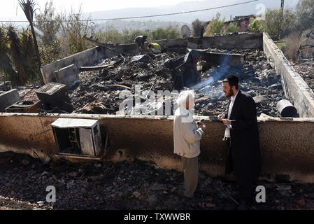 Les Israéliens inspecter les maisons détruites par un incendie dans la colonie juive d Hamalish en Cisjordanie, le 27 novembre 2016. Plusieurs cocktails Molotov ont été trouvés dans la zone de peuplement où quarante-cinq maisons ont été endommagées et 18 complètement détruites. Plus d'une dizaine de suspects ont été arrêtés pour avoir intentionnellement d'allumer des feux qui ont déshonoré Israël et la Cisjordanie. Le Premier ministre israélien Benjamin Netanyahu et les membres de son gouvernement extrémiste ont accusé les Palestiniens de l'allégement des incendies. Quelque 560 maisons ont été incendiées dans tout le pays tandis que les pompiers Palestiniens israéliens se sont joints à figh Banque D'Images