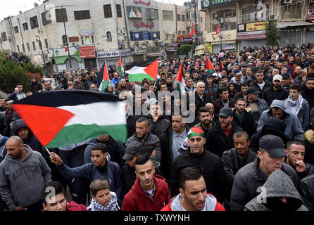 Vague de drapeaux nationaux palestiniens et de chanter des slogans au cours d'une manifestation contre le président américain Donald Trump's reconnaissance de Jérusalem comme capitale d'Israël lors d'une manifestation à Ramallah, Cisjordanie, le 7 décembre 2017. Photo par Debbie Hill/UPI Banque D'Images