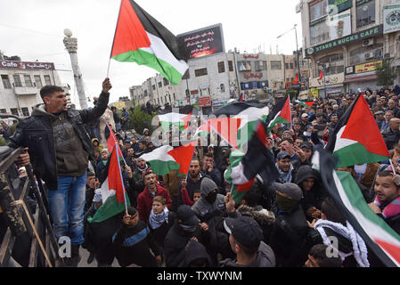 Vague de drapeaux nationaux palestiniens et de chanter des slogans au cours d'une manifestation contre le président américain Donald Trump's reconnaissance de Jérusalem comme capitale d'Israël lors d'une manifestation à Ramallah, Cisjordanie, le 7 décembre 2017. Photo par Debbie Hill/UPI Banque D'Images