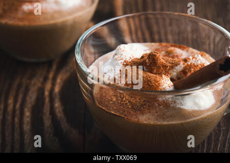 Pumpkin spice latte garnie de crème fouettée et les épices pour tarte à la citrouille sur le dessus en verre mug Banque D'Images