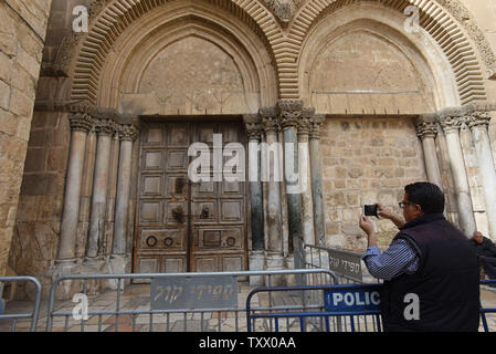 Un touriste prend une photo de la verrouillage des portes de l'église du Saint-Sépulcre dans la vieille ville de Jérusalem, après avoir fermé des leaders chrétiens l'église en signe de protestation contre les projets israéliens d'exproprier les terres de l'église de Jérusalem et de recueillir 186 millions de dollars d'arriérés d'impôts des églises, le 25 février 2018. L'église du Saint Sépulcre est que l'on croit être le site où Jésus Christ a été crucifié, enterré et ressuscité et une destination importante pour les pèlerins chrétiens. Photo par Debbie Hill/UPI Banque D'Images