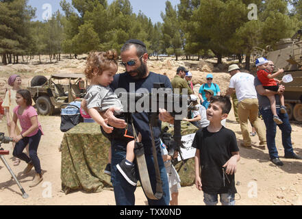 Un homme juif montre son enfant une arme d'assaut sur le 70e jour de l'indépendance d'Israël à un affichage militaire dans le Ma'ale Adumim colonie juive en Cisjordanie, le 19 avril 2018. Photo par Debbie Hill/UPI Banque D'Images