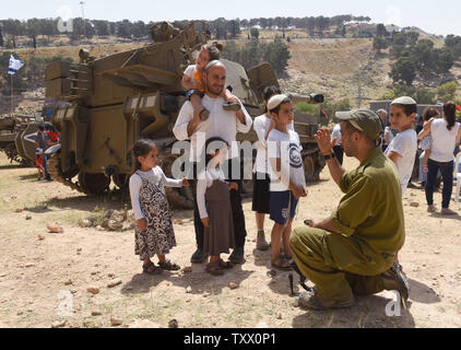Un soldat israélien parle d'une famille juive sur le 70e jour de l'indépendance d'Israël à un affichage militaire dans le Ma'ale Adumim colonie juive en Cisjordanie, le 19 avril 2018. Photo par Debbie Hill/UPI Banque D'Images