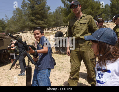 Un garçon juif détient une arme d'assaut sur le 70e jour de l'indépendance d'Israël à un affichage militaire dans le Ma'ale Adumim colonie juive en Cisjordanie, le 19 avril 2018. Photo par Debbie Hill/UPI Banque D'Images