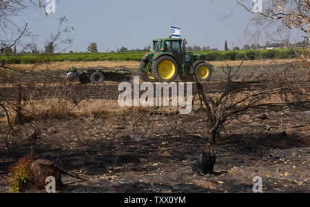 Un tracteur avec un drapeau israélien travaille dans un domaine de Kibbutz Kfar Azza, près de la frontière de la bande de Gaza, qui a été déclenché par les cerfs-volants envoyés par les manifestants palestiniens à Gaza, le 5 juin 2018. Plus de 600 cerfs-volants ont été transportés en Israël à partir de la bande de Gaza, détruisant les 9000 mètres carrés de cultures et des forêts. Photo par Debbie Hill/UPI Banque D'Images