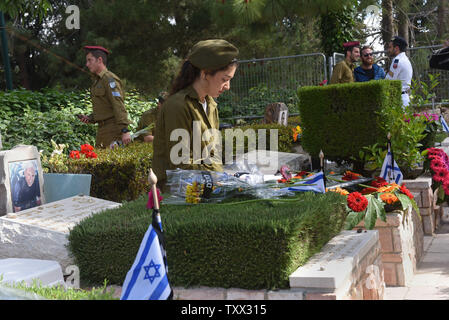 Un soldat israélien est assis sur les tombes de soldats tombés dans le Mt. Cimetière militaire de Herzl à Jérusalem, le Jour du souvenir d'Israël pour les soldats et les victimes de la terreur, le 8 mai 2019. Des milliers d'Israéliens se sont rassemblés dans les cimetières militaires à travers le pays pour se souvenir de 23 741 soldats et 3 150 victimes de la terreur. Photo par Debbie Hill/UPI Banque D'Images