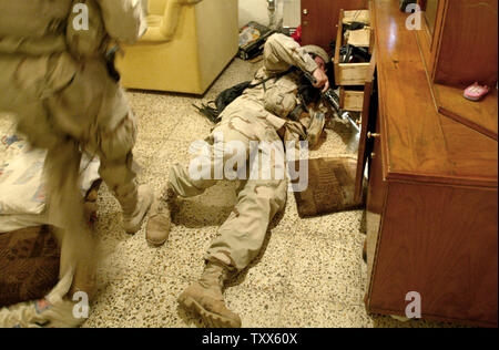 Les soldats du 3e Peloton, la Compagnie Charlie, 1-184, Bataillon d'infanterie de la Garde nationale de l'Armée de la Californie, vous pouvez la recherche d'insurgés chambre au cours d'un raid nocturne à Bagdad, l'Iraq le 17 juin 2005. Cinq insurgés présumés ont été capturés à l'opération Camel toe, un raid mené conjointement par les soldats de la Garde nationale de Californie, la police irakienne et l'armée iraquienne. (Photo d'UPI/Ken James) Banque D'Images