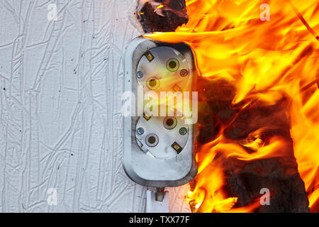 Feu électrique dans la prise murale double dans l'appartement. Sortie défectueuse est la cause du feu électrique. Banque D'Images