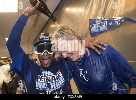 Kansas City Royals' Alcides Escobar verse du Champagne sur l'entraîneur de première Rusty Kuntz comme ils célébrer dans le vestiaire après les Royals a remporté le championnat de série américaine quitter après avoir défait les Blue Jays de Toronto 4-3 dans le jeu 6 à Kaufman Stadium de Kansas City le 23 octobre 2015. Hosmer conduit home le jeu gagnant. Photo par Kevin Dietsch/UPI Banque D'Images