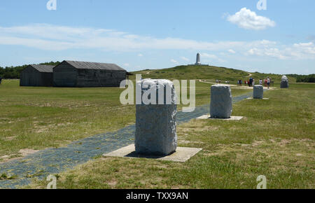 Marqueurs pour la troisième, deuxième et premier points de débarquement pour les premiers vols des frères Wright peut être vu à l'Wright Brothers National Memorial de Kill Devil Hills, près de Kitty Hawk sur les Outer Banks de la Caroline du Nord le 25 juillet 2015. À gauche sont des répliques de l'avion et le logement pour les frères. Orville et Wilbur Wright ont fait leurs essais de planeur de 1900 et a volé le premier avion sur cette plage de sable fin le 17 décembre 1903. Le premier vol ce jour parcouru 120 pieds et a duré 12 secondes, le quatrième a 852 pieds et a duré 59 secondes. Photo de Pat Banque D'Images