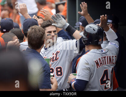 Frappeur désigné des Detroit Tigers Victor Martinez (R) haute de cinq ans coéquipier J.D. Martinez après J.D. a frappé un home run run trois Victor de notation et Miguel Cabrera au cours de la quatrième manche du Match 2 de la Division de la ligue américaine contre la série Baltimore Orioles à Orioles Park at Camden Yards de Baltimore, Maryland le 3 octobre 2014. UPI/Kevin Dietsch Banque D'Images