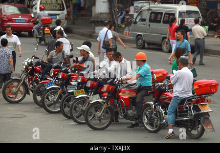 Les chauffeurs de taxi moto attendre pour les passagers au centre-ville de Guiyang, la capitale de la province du Guizhou le 22 juillet 2013. Une enquête récente a montré que l'écart de richesse bâillement-déjà entre les différentes régions et industries en Chine se creuse, avec près de 50  % de l'écart résultant de disparités rurales-urbaines. UPI/Stephen Shaver Banque D'Images