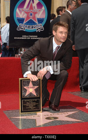 Ryan Seacrest, diffuseur hôte de l'émission de télévision 'American Idol' contient une réplique de la plaque de sa nouvelle star au cours d'une cérémonie de dévoilement sur le Hollywood Walk of Fame à Los Angeles le 20 avril 2005. Seacrest a été honoré avec le 282e, 2 étoiles pour ses réalisations dans la radiodiffusion. (Photo d'UPI/Jim Ruymen) Banque D'Images