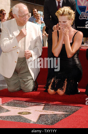 L'actrice Charlize Theron (R) réagit à côté de Johnny Grant, maire honoraire de Hollywood, en voyant sa nouvelle étoile sur le Hollywood Walk of Fame à Los Angeles le 29 septembre 2005. Theron, dont le prochain film est le drame 'pays du Nord', a reçu le 2,291e étoile sur le Walk of Fame. (Photo d'UPI/Jim Ruymen) Banque D'Images