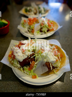 Baja beer battered fish tacos trois assiettes sur une table Banque D'Images