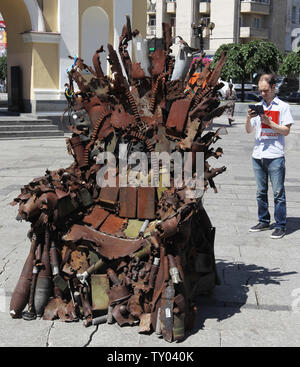 25 juin 2019 - Kiev, Ukraine - un homme prend une photo de l'album 'Le Trône de fer de l'Est' d'art, qui a présenté sur la place de l'indépendance, à Kiev, Ukraine, le 25 juin 2019. "Le trône de fer de l'Est' a été créé un bénévole ukrainienne fighter Denis Bushtets dans la zone de conflit de la guerre dans l'Est de l'Ukraine près de Donetsk en 2016. L'objet d'art est faite à partir de l'épave de l'armure du réservoir, parties de démoli le matériel militaire, mitrailleuses, obus, cartouches et flacons du soldat et il n'est plus de 600 kg de poids. Un prototype d'un célèbre discours du Trône de fer Game of Thrones série TV est un rappel d'un bl Banque D'Images