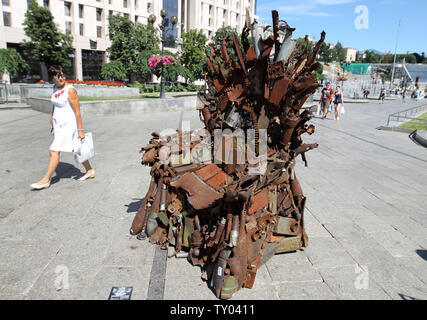 25 juin 2019 - Kiev, Ukraine - une femme cherche sur le trône de fer le 'l'Est' d'art, qui a présenté sur la place de l'indépendance, à Kiev, Ukraine, le 25 juin 2019. "Le trône de fer de l'Est' a été créé un bénévole ukrainienne fighter Denis Bushtets dans la zone de conflit de la guerre dans l'Est de l'Ukraine près de Donetsk en 2016. L'objet d'art est faite à partir de l'épave de l'armure du réservoir, parties de démoli le matériel militaire, mitrailleuses, obus, cartouches et flacons du soldat et il n'est plus de 600 kg de poids. Un prototype d'un célèbre discours du Trône de fer Game of Thrones série TV est un rappel d'une sanglante c Banque D'Images