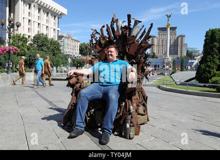 25 juin 2019 - Kiev, Ukraine - Un homme est assis sur le trône de fer de l'Est' d'art, qui a présenté sur la place de l'indépendance, à Kiev, Ukraine, le 25 juin 2019. "Le trône de fer de l'Est' a été créé un bénévole ukrainienne fighter Denis Bushtets dans la zone de conflit de la guerre dans l'Est de l'Ukraine près de Donetsk en 2016. L'objet d'art est faite à partir de l'épave de l'armure du réservoir, parties de démoli le matériel militaire, mitrailleuses, obus, cartouches et flacons du soldat et il n'est plus de 600 kg de poids. Un prototype d'un célèbre discours du Trône de fer Game of Thrones série TV est un rappel d'une sanglante conf Banque D'Images