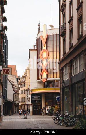 Strasbourg, France - Juillet 22, 2017 : Avis de cinema Vox cinéma dans le centre de Strasbourg avec de grandes lettres de néon rouge et la famille marche dans la rue Banque D'Images