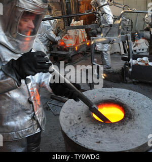 Ouvriers préparer le métal bronze fondu pour être coulée dans des moules, l'arrière, c'est au casting de la Screen Actors Guild Award statuettes à l'American Fine Arts fonderie à Burbank, Californie le 14 janvier 2009. L'acteur statuettes seront remis aux lauréats lors de la 15e édition annuelle de SAG Awards a eu lieu le 25 janvier à Los Angeles. (Photo d'UPI/Jim Ruymen) Banque D'Images