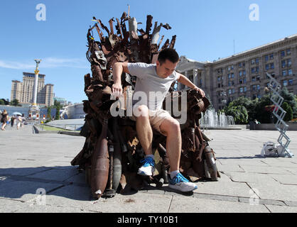 25 juin 2019 - Kiev, Ukraine - Un homme est assis sur le trône de fer de l'Est' d'art, qui a présenté sur la place de l'indépendance, à Kiev, Ukraine, le 25 juin 2019. "Le trône de fer de l'Est' a été créé un bénévole ukrainienne fighter Denis Bushtets dans la zone de conflit de la guerre dans l'Est de l'Ukraine près de Donetsk en 2016. L'objet d'art est faite à partir de l'épave de l'armure du réservoir, parties de démoli le matériel militaire, mitrailleuses, obus, cartouches et flacons du soldat et il n'est plus de 600 kg de poids. Un prototype d'un célèbre discours du Trône de fer Game of Thrones série TV est un rappel d'une sanglante conf Banque D'Images