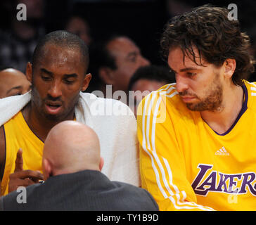 Los Angeles Lakers Kobe Bryant garde des grimaces, en tant que formateur Gary Vitti examine son tir fracturée doigt après Bryant blessé d'atteindre d'un laissez-passer, au cours du premier trimestre à l'égard de la Minnesota Timberwolves à Los Angeles le 11 décembre 2009. Bryant a marqué 20 points malgré le port d'une attelle sur son index dans la seconde moitié. Les Lakers défait les Timberwolves 104-92 pour leur 11e victoire consécutive. À la recherche sur son coéquipier Pau Gasol est de l'Espagne. UPI/Jim Ruymen Banque D'Images