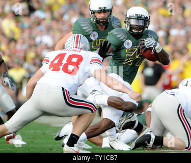 Oregon Ducks' d'utiliser de nouveau Kenjon Barner bras raide Ohio State Buckeyes' defender Spencer Thoma dans la première moitié du 96e jeu Rose Bowl de Pasadena, Californie, le 1er janvier 2010. UPI/Jon SooHoo Banque D'Images