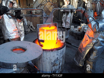 Les travailleurs de fire convient à se préparer à verser dans des moules en métal bronze fondu pendant le coulage de la Screen Actors Guild Award statuettes, à l'American Fine Arts Foundry le 21 janvier 2011 à Burbank, Californie. La remise des prix auront lieu à Los Angeles le 30 janvier. UPI/Jim Ruymen Banque D'Images