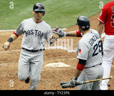Red Sox de Boston Marco Scutaro (10) marque un point et est félicité par Adrian Gonzalez (28) contre les Los Angeles Angels de la cinquième manche au Angel Stadium à Anaheim, Californie le 24 avril 2011. Les Red Sox ont remporté 7-0. UPI/Lori Shepler. Banque D'Images