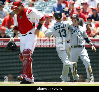 Mariners de Seattle' Dustin Ackley (13) et Brendan Ryan, droite, féliciter les uns les autres après avoir marqué en première manche comme Los Angeles Angels catcher Jeff Mathis regarde vers le bas au Angel Stadium à Anaheim, Californie le 10 juillet 2011. Les Anges a gagné 4-2. UPI/Lori Shepler. Banque D'Images