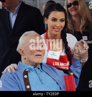 Kim Kardashian pose avec l'hôte, l'acteur Kirk Douglas alors qu'elle se joint à une série de célébrités en servant un traditionnel repas de Thanksgiving pour les sans-abri à la mission de Los Angeles, dans la section des clochards de Los Angeles le 23 novembre 2011. UPI/Jim Ruymen Banque D'Images