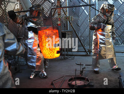 Les travailleurs de fire convient à se préparer à verser dans des moules en métal bronze fondu pendant le coulage de la Screen Actors Guild Award statuettes, à l'American Fine Arts fonderie à Burbank, Californie le 19 janvier 2012. La remise des prix auront lieu à Los Angeles le 29 janvier 2012. UPI/Jim Ruymen Banque D'Images