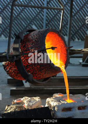 Les travailleurs de fire convient à verser dans des moules en métal bronze fondu pendant le coulage de la Screen Actors Guild Award statuettes, à l'American Fine Arts fonderie à Burbank, Californie le 19 janvier 2012. La remise des prix auront lieu à Los Angeles le 29 janvier 2012. UPI/Jim Ruymen Banque D'Images