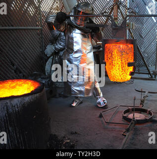 Les travailleurs de fire convient à se préparer à verser dans des moules en métal bronze fondu pendant le coulage de la Screen Actors Guild Award statuettes, à l'American Fine Arts fonderie à Burbank, Californie le 19 janvier 2012. La remise des prix auront lieu à Los Angeles le 29 janvier 2012. UPI/Jim Ruymen Banque D'Images