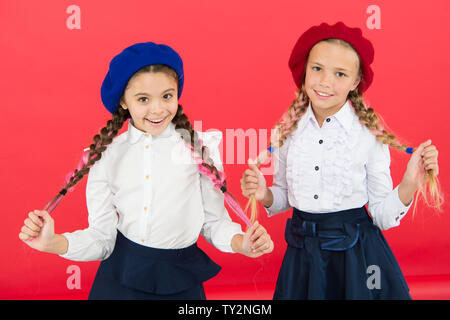 L'École de l'amitié. Sur la même vague. Usure uniforme de l'école formelle écolières. Les enfants belles filles de long cheveux tressés. Style de fantaisie. Peu de filles avec des tresses, des prêts pour l'école. Concept de la mode de l'école. Banque D'Images