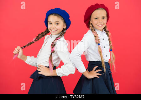 Sur la même vague. Usure uniforme de l'école formelle écolières. Les enfants belles filles de long cheveux tressés. Peu de filles avec des tresses, des prêts pour l'école. Concept de la mode de l'école. Style de fantaisie. L'École de l'amitié. Banque D'Images