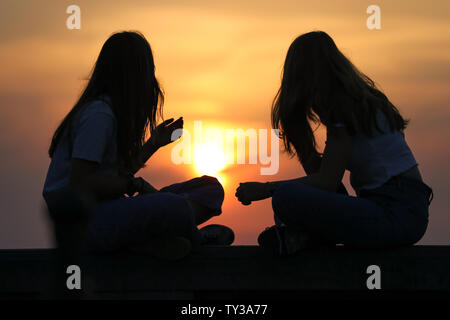 Bruxelles. 25 Juin, 2019. Les touristes regarder le coucher du soleil à Infantry Monument Mémorial Square à Bruxelles, Belgique le 25 juin 2019. Une vague de chaleur a frappé de nombreuses régions de l'Europe de l'Ouest cette semaine, avec des températures de plus de 40 degrés Celsius dans certaines régions. Credit : Zhang Cheng/Xinhua/Alamy Live News Banque D'Images